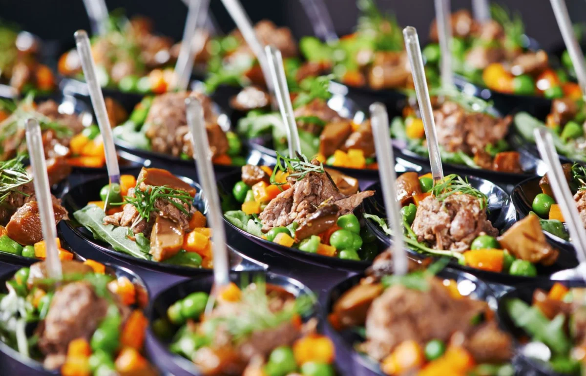 Bouchées créatives et colorées avec légumes frais et viande en sauce, illustrant le raffinement culinaire et la créativité du traiteur.