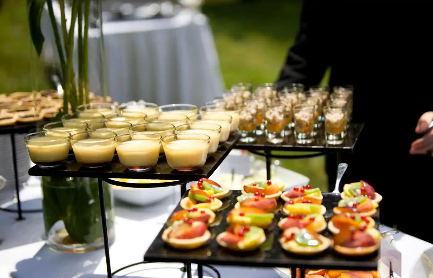 Table de cocktails avec verrines et bouchées élégantes, illustrant l'offre raffinée de zakouskis et desserts pour une réception.