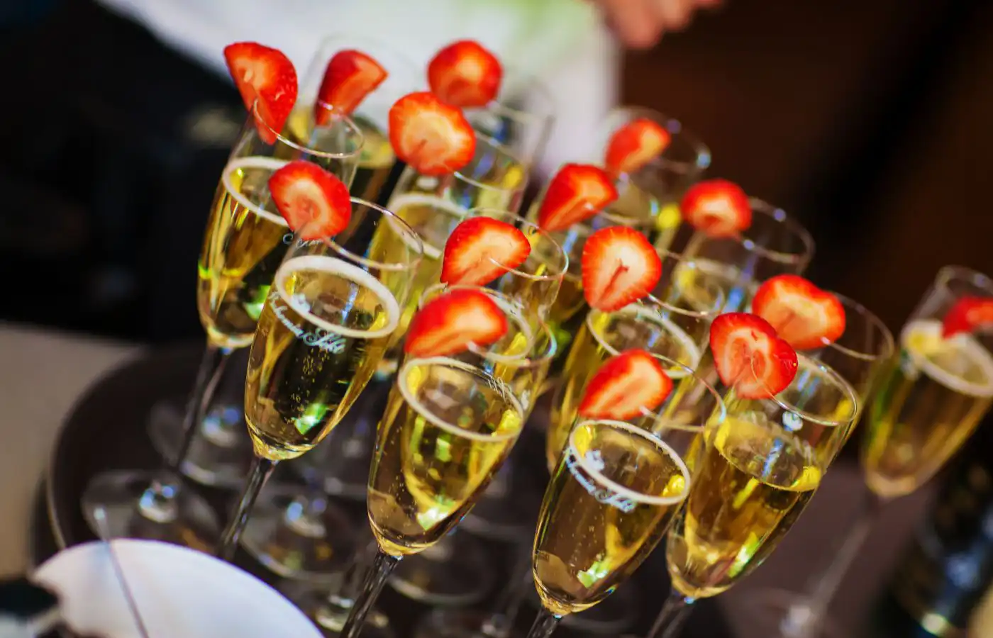 Verres de champagne garnis de fraises fraîches, prêts à être servis pour un drink d'accueil élégant.